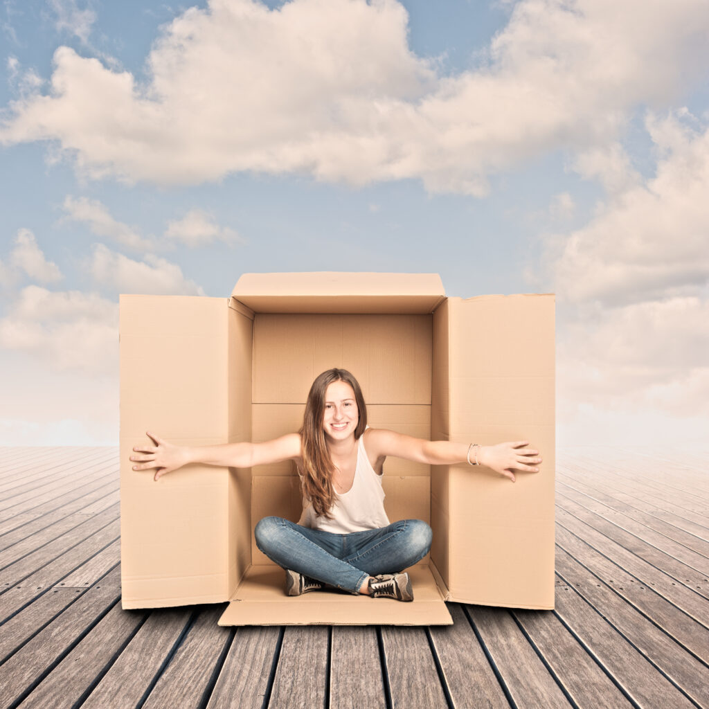 young woman sitting inside open box