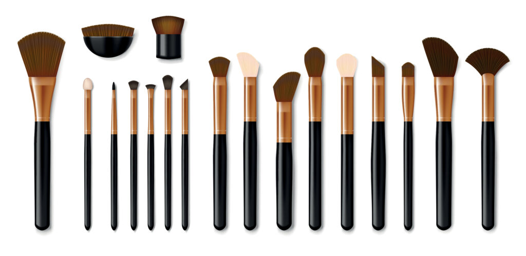 A beauty toolbox of 18 makeup brushes featuring sleek black handles and elegant copper ferrules. This versatile set includes fan, angled, blending, and flat brushes, all arranged neatly in two rows for the perfect makeup application.