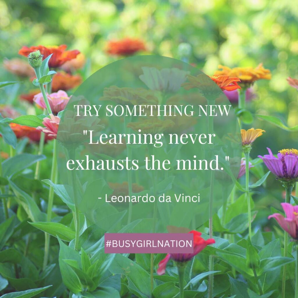 A garden with vibrant flowers in the background and weeds tucked aside. Overlaid text reads, TRY SOMETHING NEW Learning never exhausts the mind. - Leonardo da Vinci. A pink tag at the bottom says #BUSYGIRLNATION.